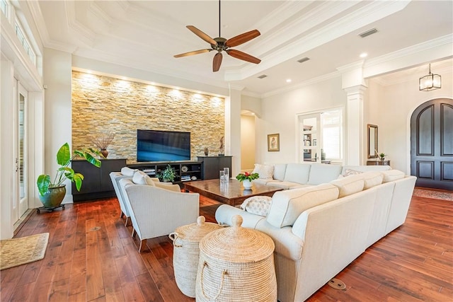 living room featuring ornamental molding, dark wood-type flooring, and a tray ceiling