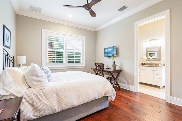 bedroom featuring crown molding, dark wood-type flooring, ceiling fan, and ensuite bath