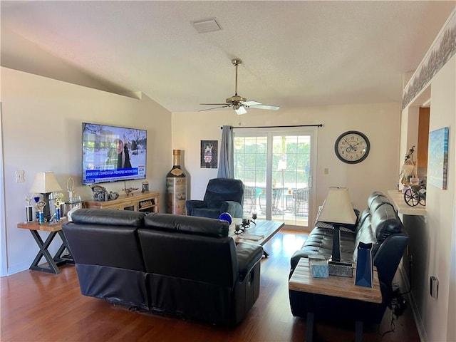 living room featuring ceiling fan, dark hardwood / wood-style floors, and vaulted ceiling