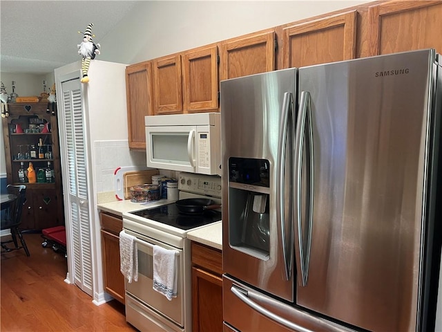 kitchen with white appliances and light hardwood / wood-style floors