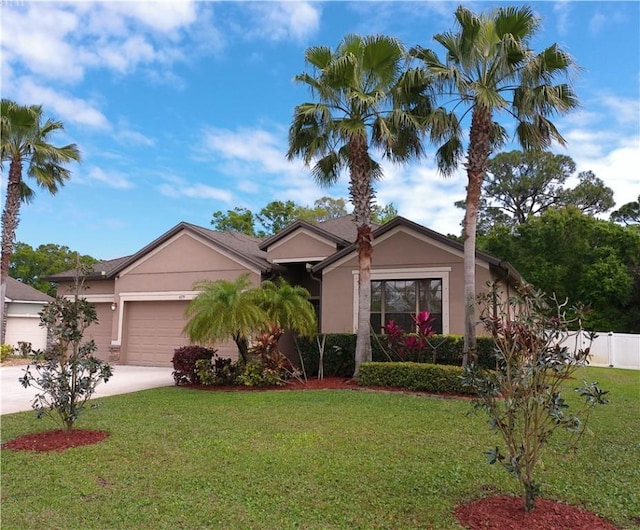 view of front of property with an attached garage, fence, concrete driveway, stucco siding, and a front lawn