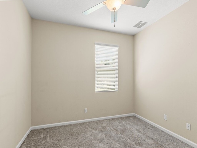 carpeted empty room featuring baseboards, visible vents, and ceiling fan