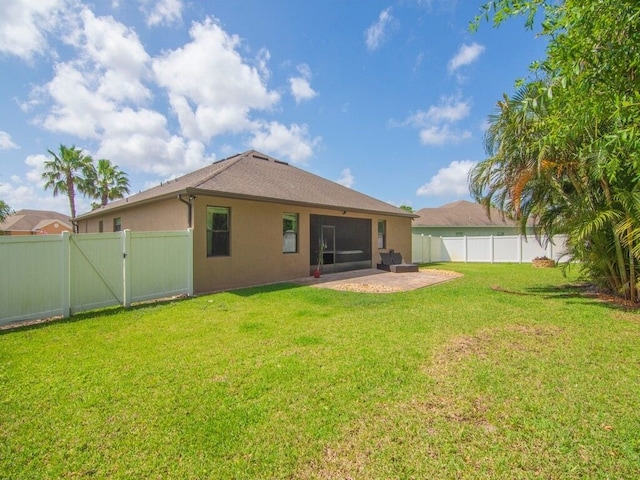 back of house featuring a gate, stucco siding, a fenced backyard, a patio, and a yard