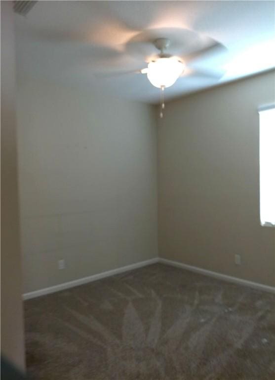 spare room with a ceiling fan, carpet, and baseboards