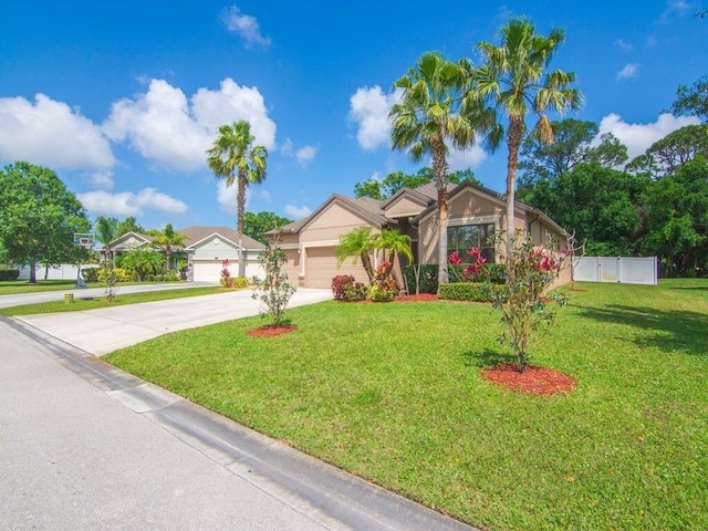 ranch-style home featuring a front lawn, fence, driveway, and a garage