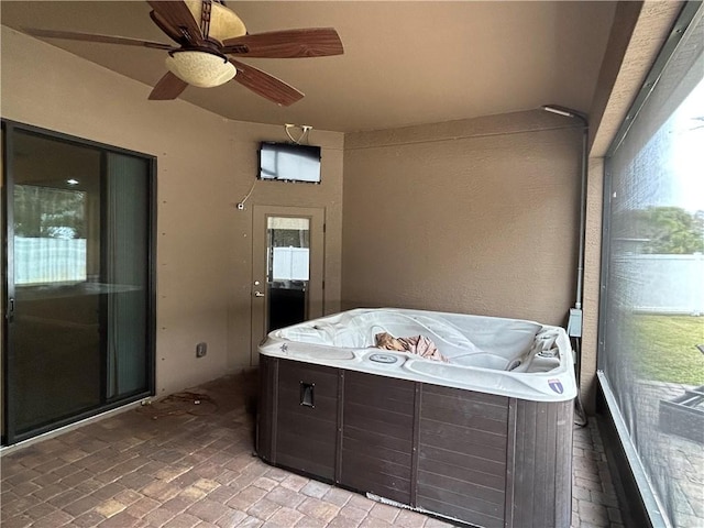 sunroom / solarium featuring a ceiling fan