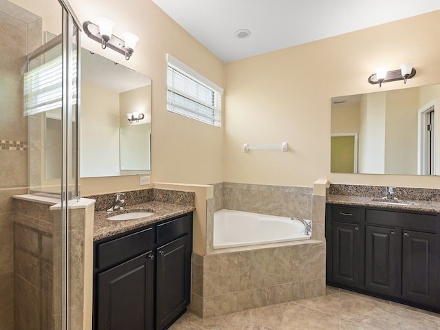 bathroom featuring a stall shower, a bath, tile patterned flooring, and a sink