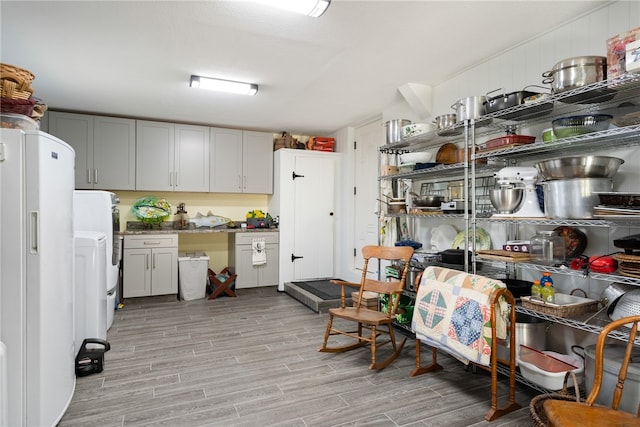 kitchen with white refrigerator and light hardwood / wood-style flooring