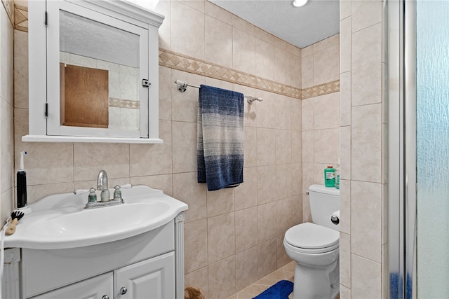 bathroom featuring toilet, vanity, tile walls, and a textured ceiling