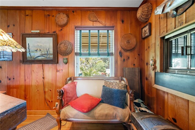 sitting room with wood walls and hardwood / wood-style flooring