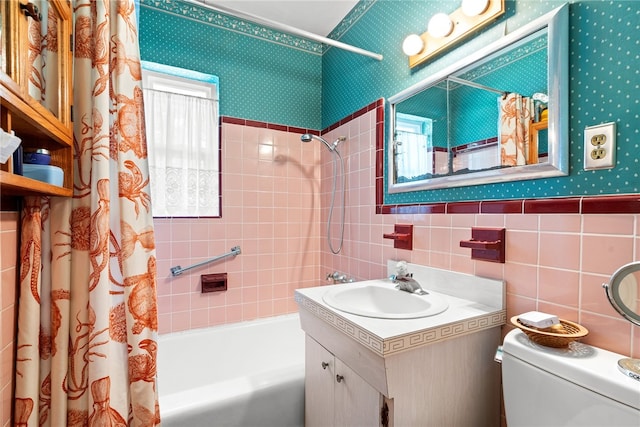 full bathroom with vanity, toilet, tile walls, and shower / bathtub combination with curtain