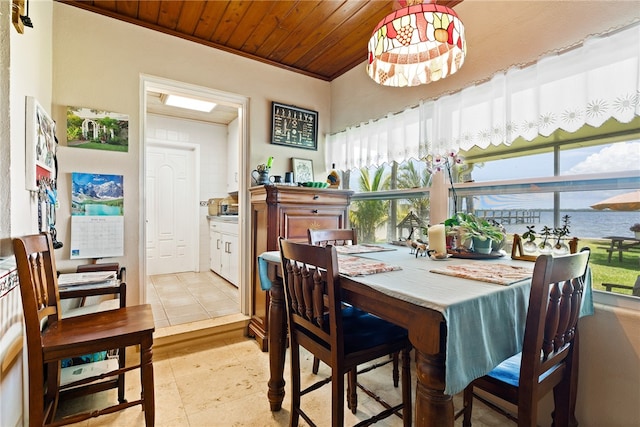 dining area featuring wooden ceiling, a water view, and crown molding