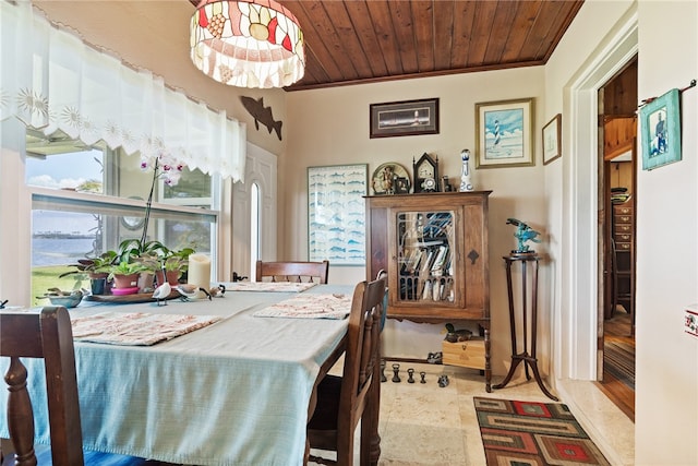 dining room featuring a water view, wood ceiling, and ornamental molding