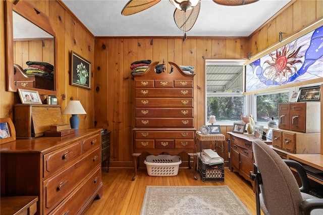 office area featuring light hardwood / wood-style floors, wooden walls, and crown molding