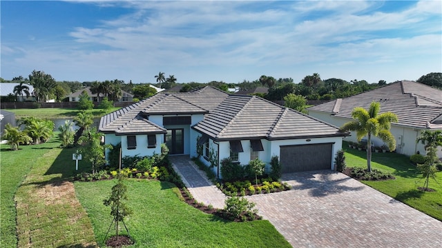 ranch-style house featuring a garage, a water view, and a front lawn