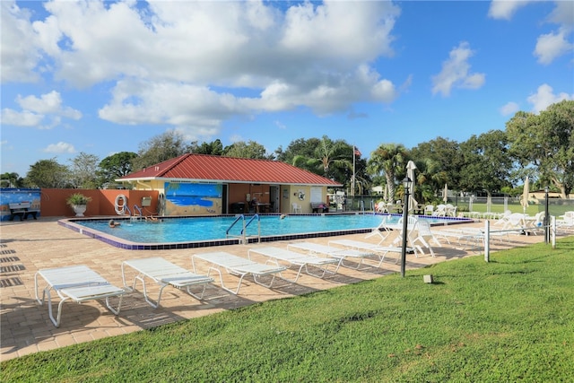 view of pool with a patio area and a yard