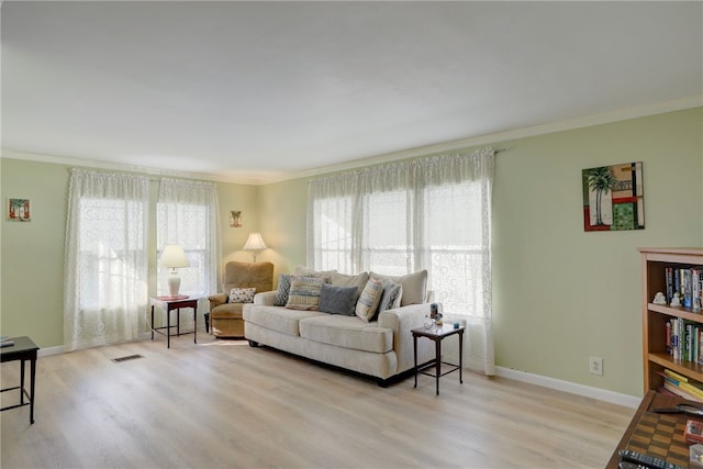 living room featuring light hardwood / wood-style floors and ornamental molding