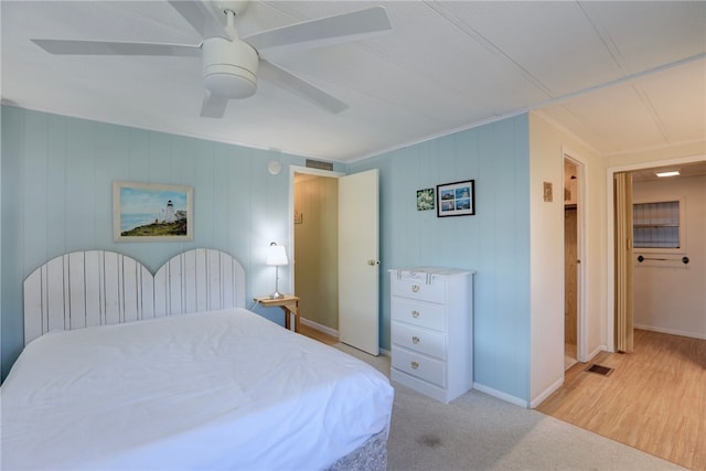 carpeted bedroom with ceiling fan and ornamental molding