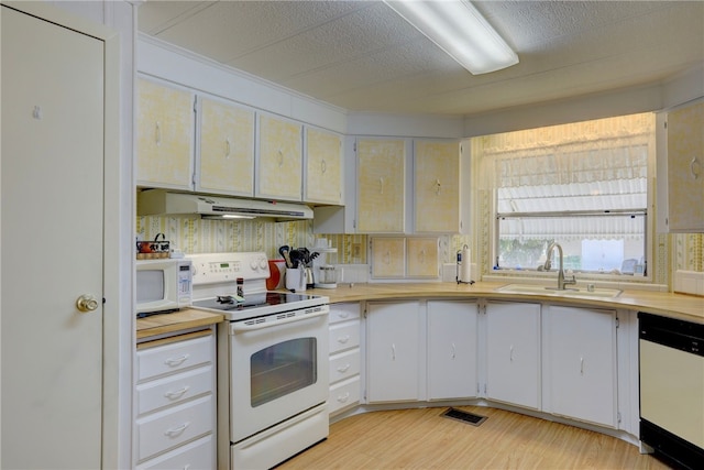 kitchen featuring sink, a textured ceiling, white appliances, white cabinets, and light wood-type flooring