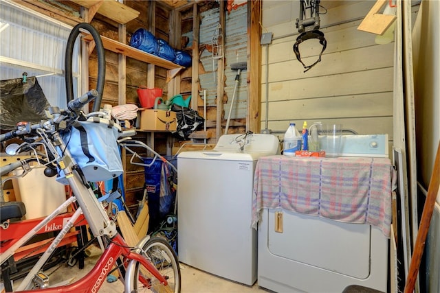 washroom with wood walls and washing machine and clothes dryer