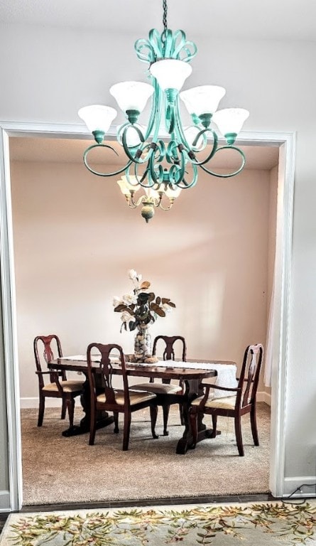 dining area featuring carpet flooring and a chandelier