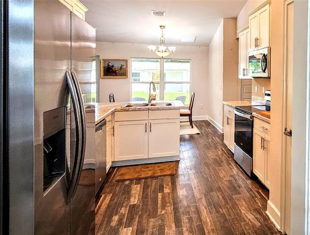 kitchen featuring sink, stainless steel appliances, an inviting chandelier, dark hardwood / wood-style floors, and decorative light fixtures