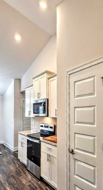 kitchen featuring white cabinets, vaulted ceiling, dark hardwood / wood-style floors, butcher block countertops, and stainless steel appliances