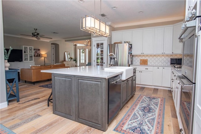 500 45th Ct SW, Vero Beach, FL 32968 - kitchen featuring dishwasher, white cabinets, stainless steel fridge, light countertops, and ornamental molding