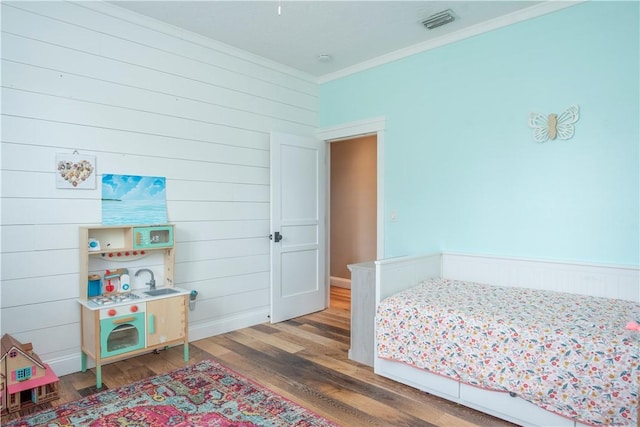 500 45th Ct SW, Vero Beach, FL 32968 - bedroom with crown molding, wood finished floors, and wood walls
