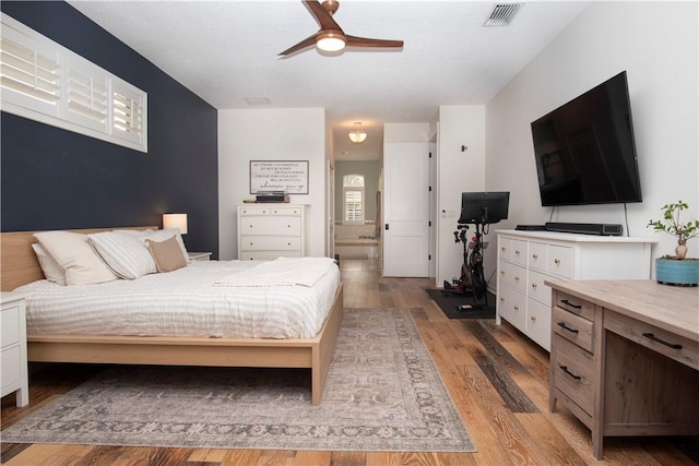 500 45th Ct SW, Vero Beach, FL 32968 - bedroom with light wood-style floors, connected bathroom, and ceiling fan