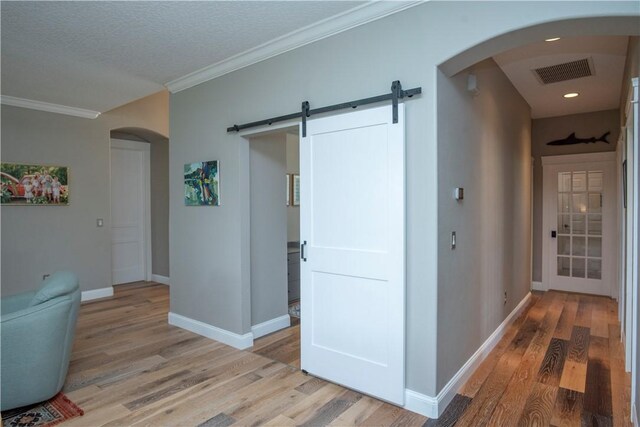 500 45th Ct SW, Vero Beach, FL 32968 - corridor with arched walkways, ornamental molding, light wood-style flooring, a barn door, and recessed lighting