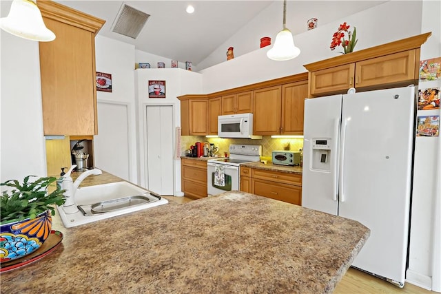 kitchen with sink, decorative backsplash, hanging light fixtures, kitchen peninsula, and white appliances