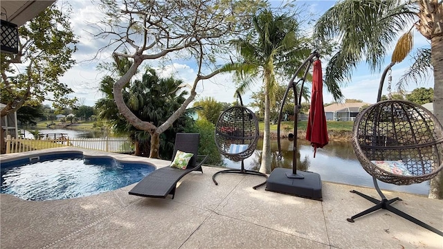 view of swimming pool with a patio area and a water view