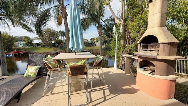 view of patio featuring an outdoor fireplace and a water view