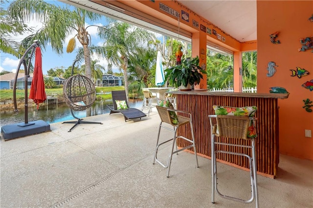 view of patio with a water view and exterior bar