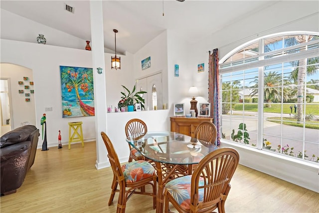 dining area featuring lofted ceiling, plenty of natural light, and light hardwood / wood-style flooring