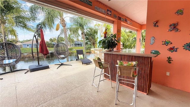 view of patio / terrace with a water view and a bar