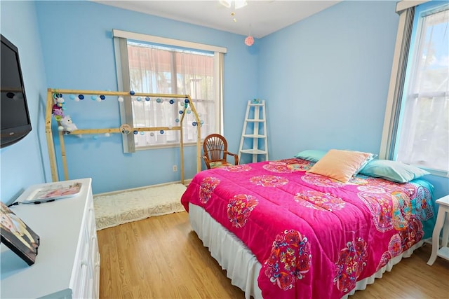 bedroom featuring multiple windows and light hardwood / wood-style flooring