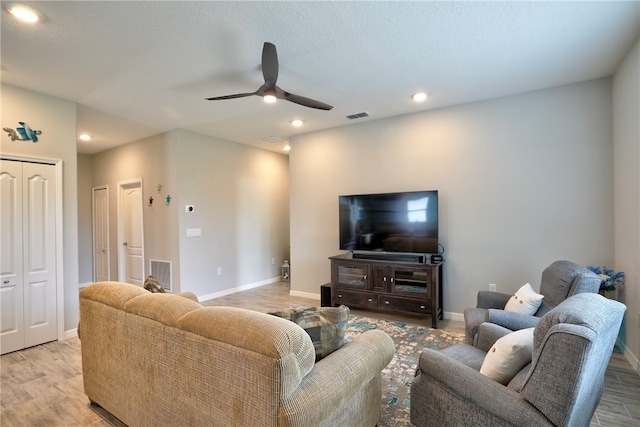 living room with light wood-type flooring and ceiling fan