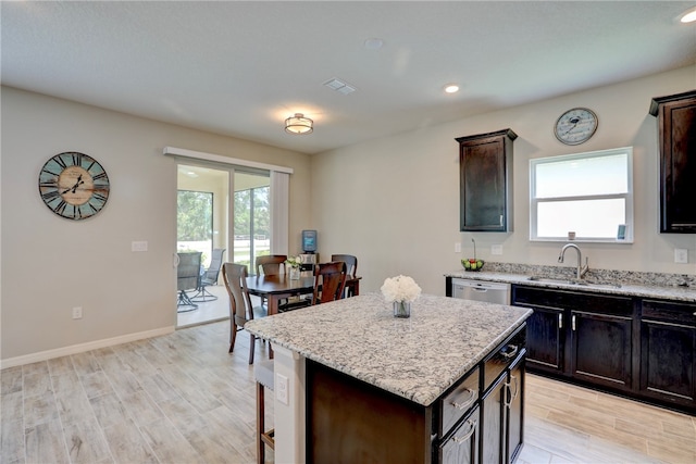 kitchen featuring light hardwood / wood-style flooring, a kitchen island, sink, and plenty of natural light