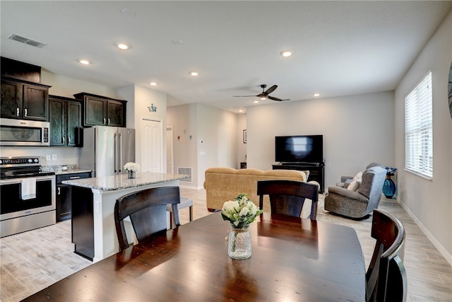 dining area with light wood-type flooring and ceiling fan