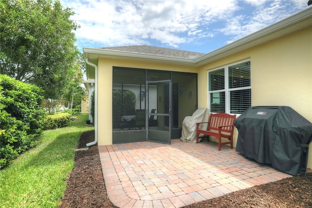 view of patio / terrace featuring a sunroom and a grill