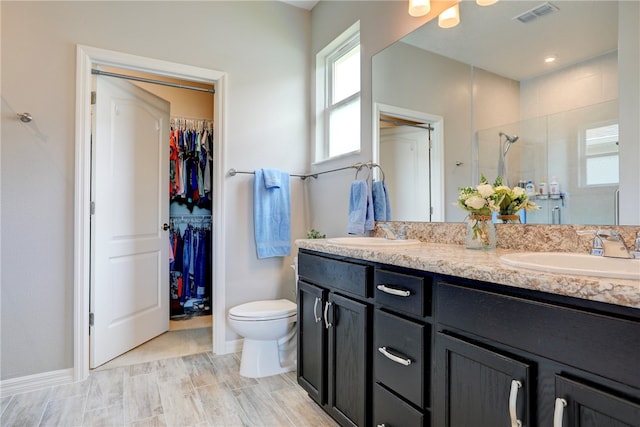 bathroom featuring vanity, hardwood / wood-style flooring, toilet, and a shower