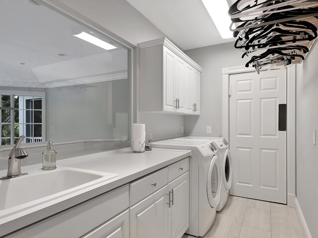 clothes washing area featuring cabinets, sink, washer and dryer, and light tile patterned flooring