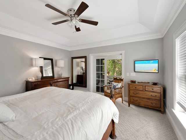 carpeted bedroom featuring ceiling fan, crown molding, and a tray ceiling