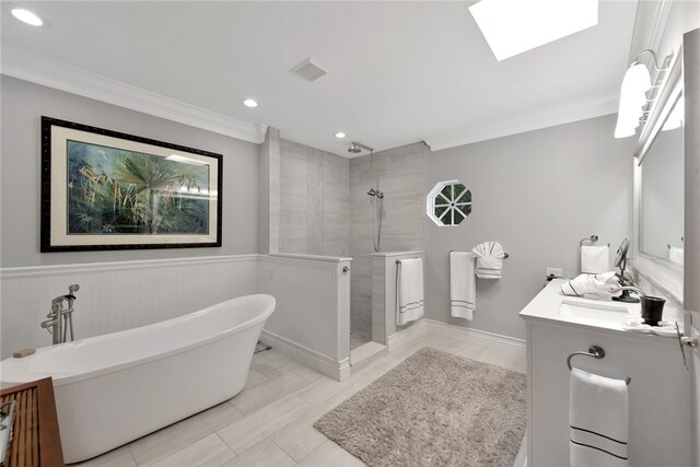 bathroom with ornamental molding, vanity, and independent shower and bath