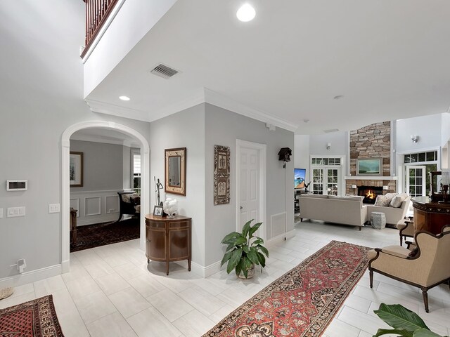 living room featuring light tile patterned floors, ornamental molding, and a fireplace