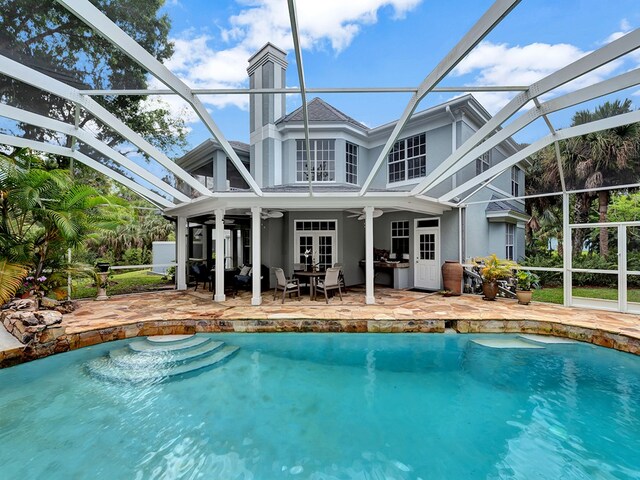 back of house with glass enclosure, a patio, and ceiling fan