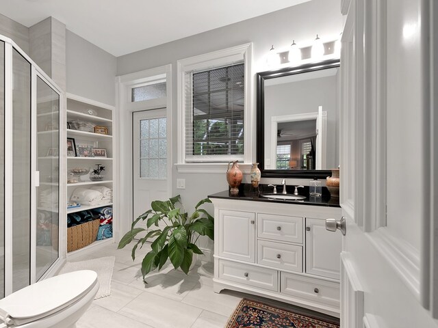 bathroom with vanity, a shower with shower door, tile patterned floors, and toilet