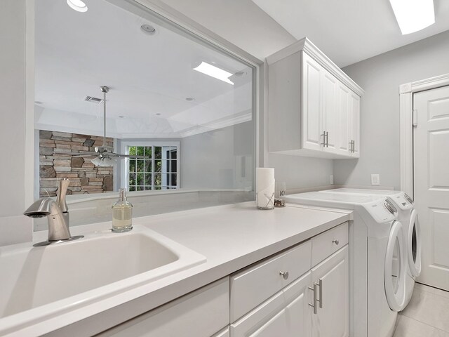 washroom featuring light tile patterned flooring, cabinets, sink, and washer and dryer